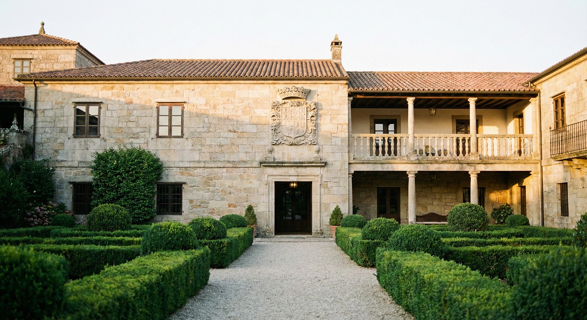 Fachada de pazo histórico con jardines maduros y camino de grava, ideal como pazo para bodas