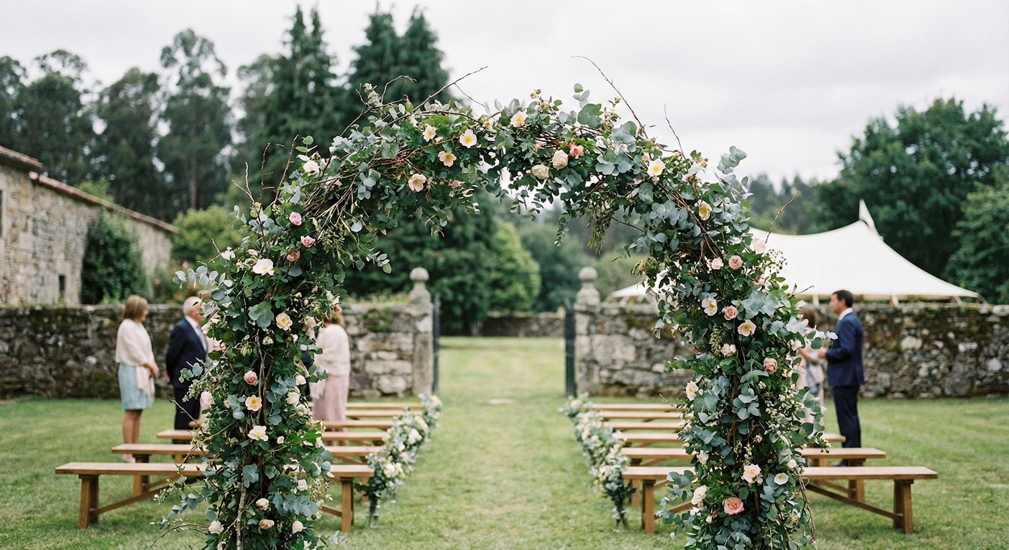 Ceremonia civil íntima en jardín de pazo con arco floral y carpa elegante al fondo