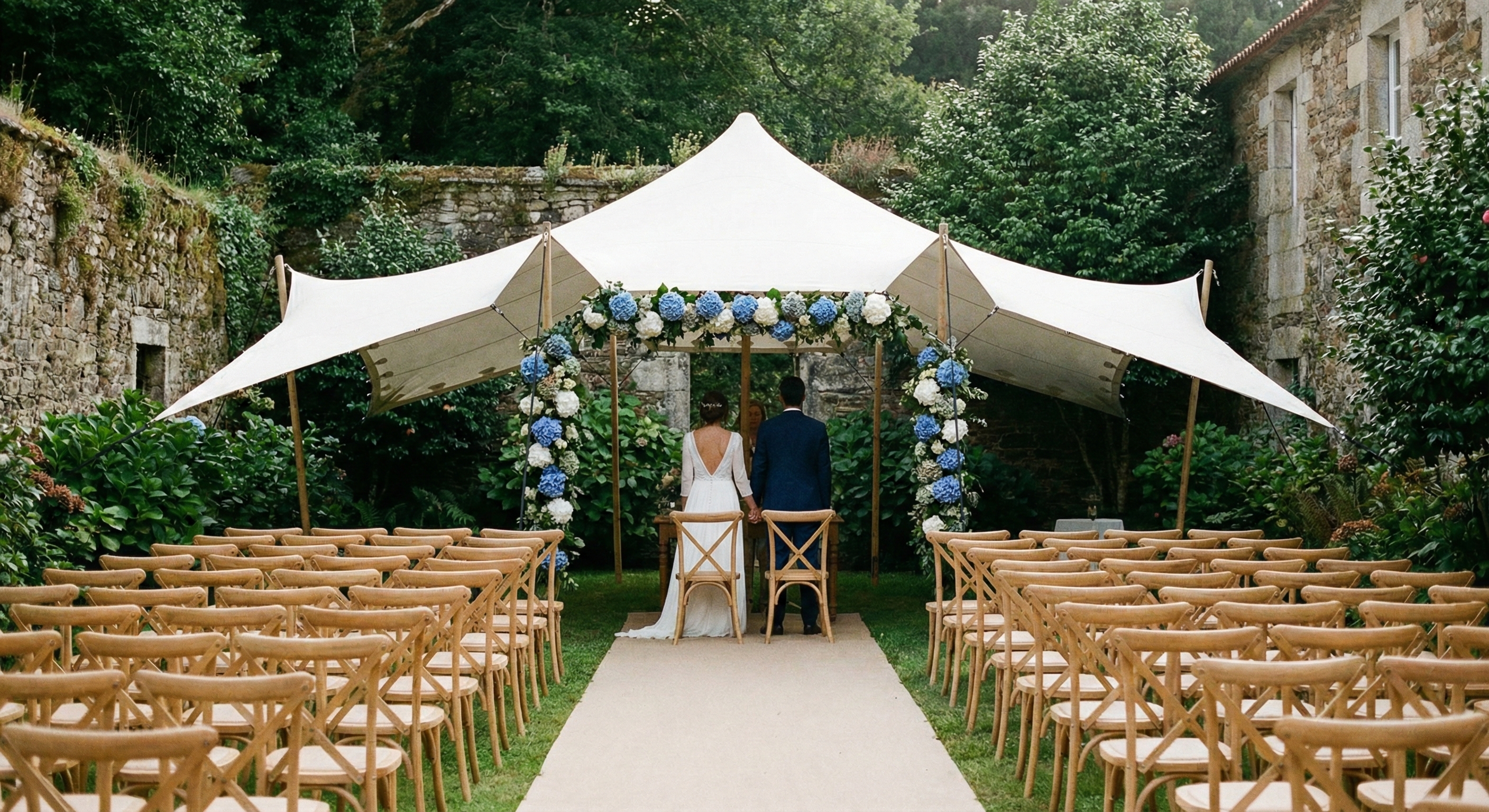 Ceremonia civil elegante en jardín amurallado de palacete indiano en Galicia, bajo carpa blanca con hortensias