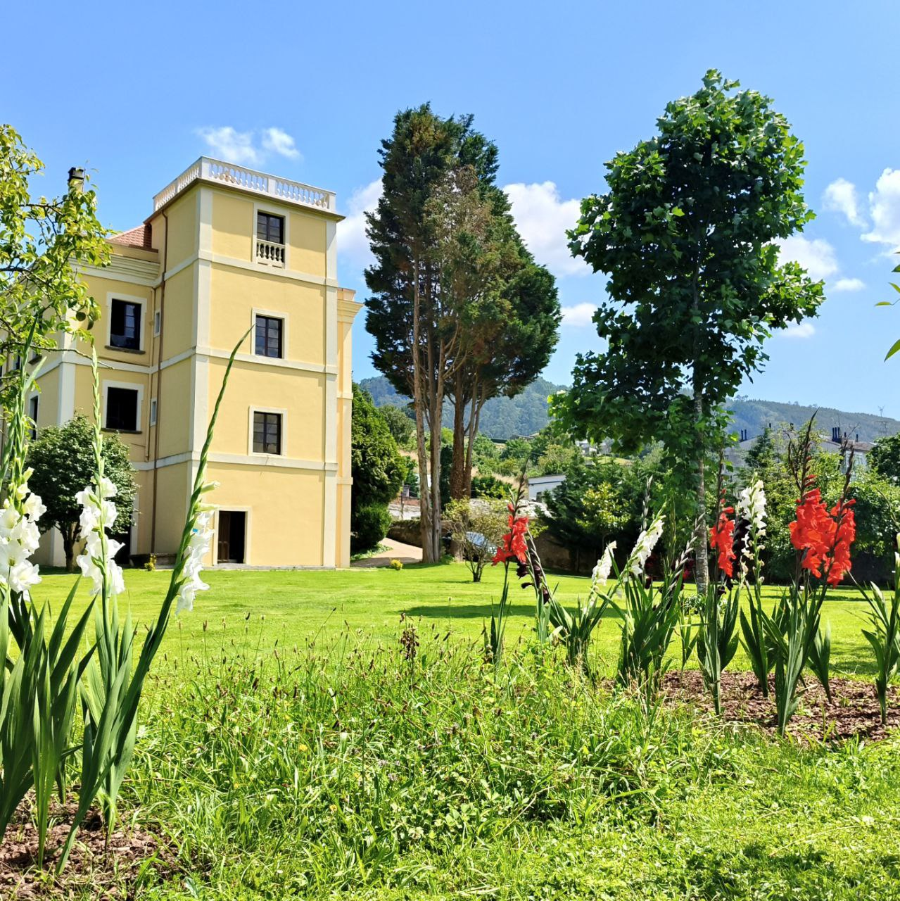 Jardin y fachada amarilla de Santa Emilia en Mondonedo