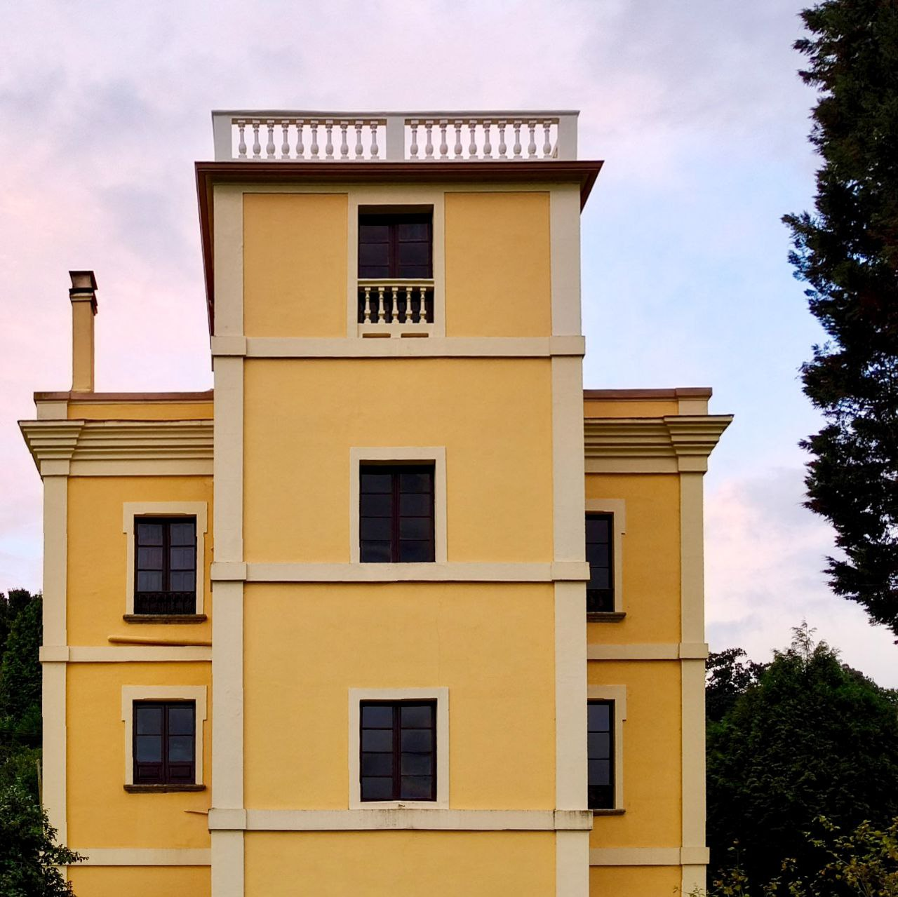 Fachada amarilla de Santa Emilia vista desde el jardín