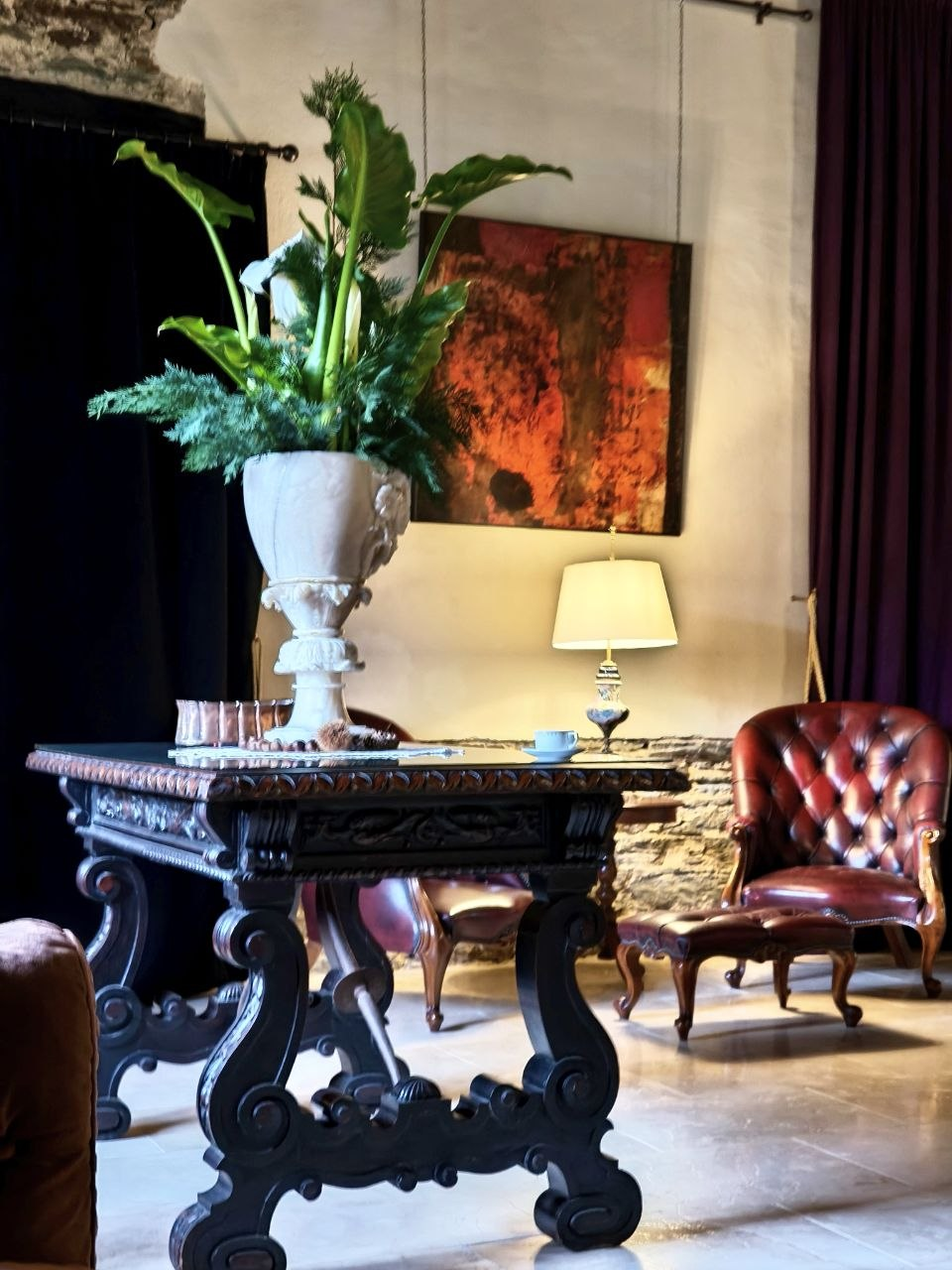 Carved wooden table and red leather chairs in the Salón de los Pilares at Santa Emilia